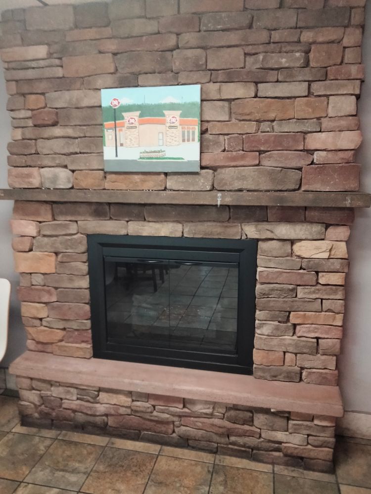 This Dairy Queen has a fireplace and a painting of itself