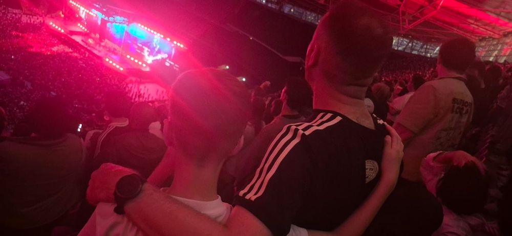 Me and my son, arm around each other, watching Oasis.