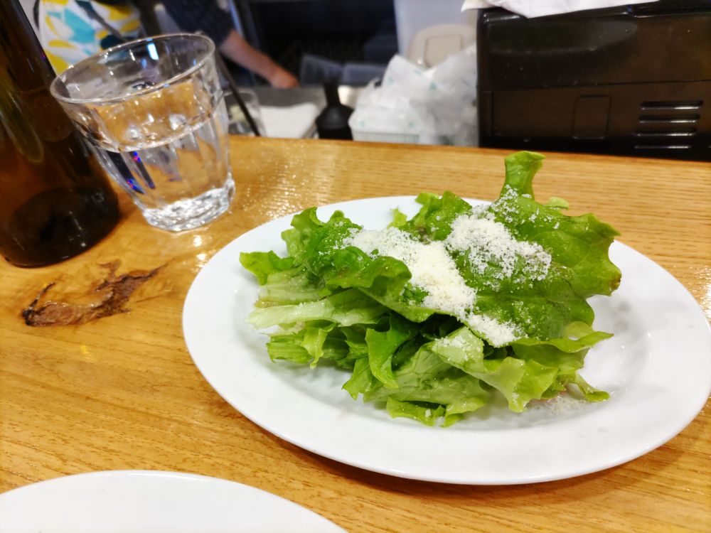 サラダはレタスの上に粉チーズと函館産ブラックベリーのビネガーがかかってる