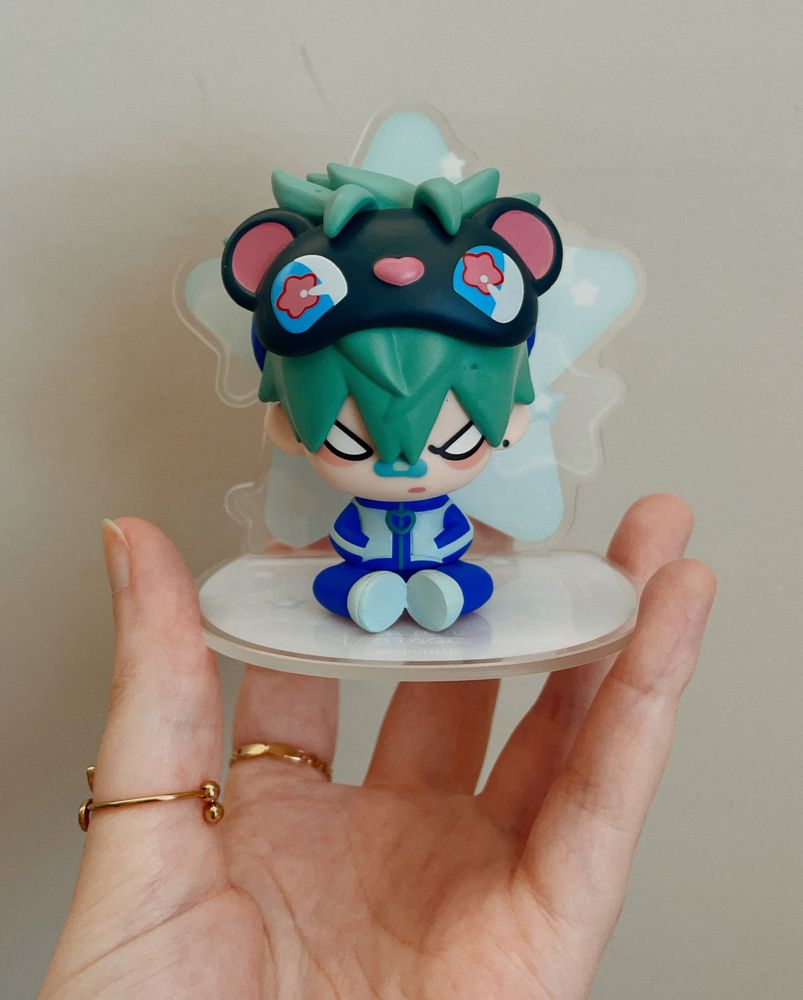 a picture of my hand holding the alien stage till figure. the background is a plain white wall. 