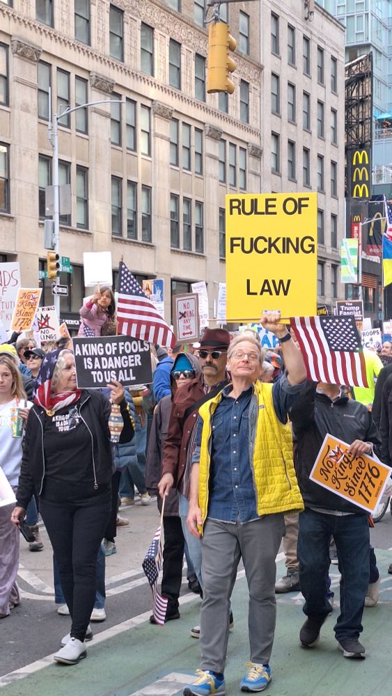 Man holding sign that says Rule of Fucking Law