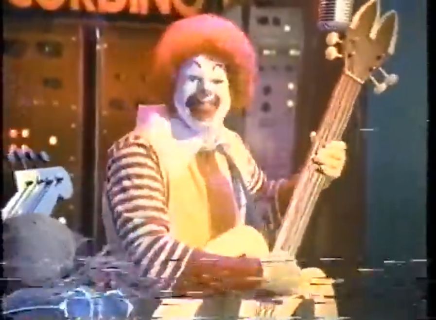 A screenshot from the 1991 McDonald's commercial "A Day in the Life".

Ronald McDonald plays an electric guitar shaped like the McDonald's Golden Arches logo.