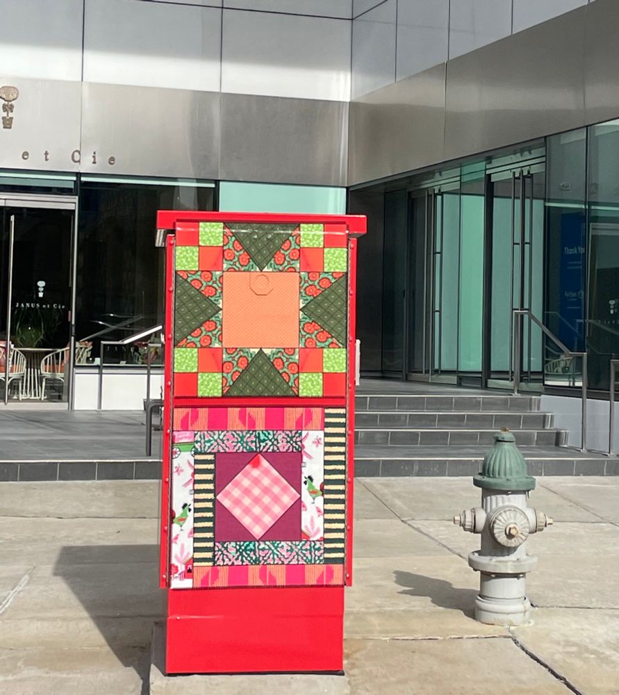 Colorful quilt blocks seen on electrical box along the street