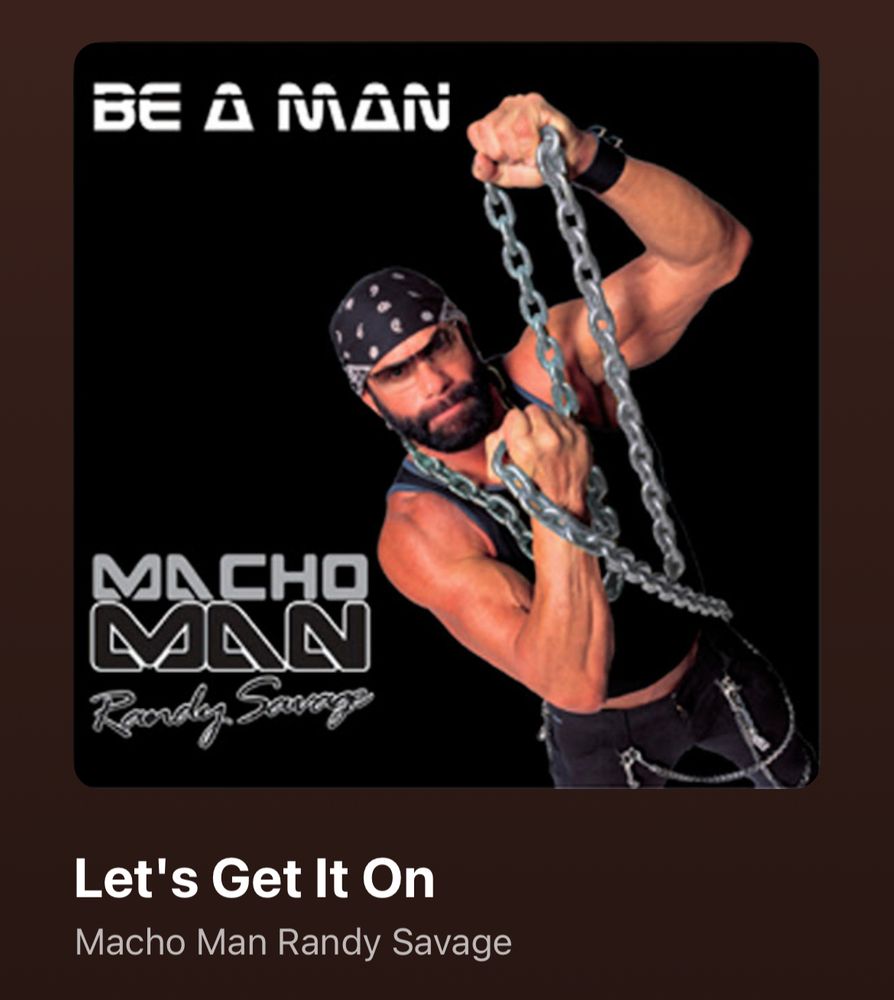 The album cover for Be A Man by Macho Man Randy Savage. Savage is in the lower right dressed in black Jeff Hardy Pants, a black tank top, a bandana and sunglasses, posing with a steel chain. Let’s Get It On is playing 