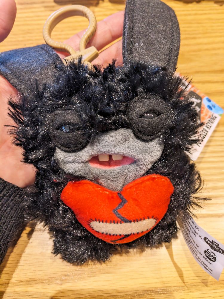 黒いもじゃもじゃの毛に包まれたファグラー。
口の周りだけグレー。
義歯2本に長い黒い耳。
絆創膏を貼った、傷ついた赤いハートを抱えている。