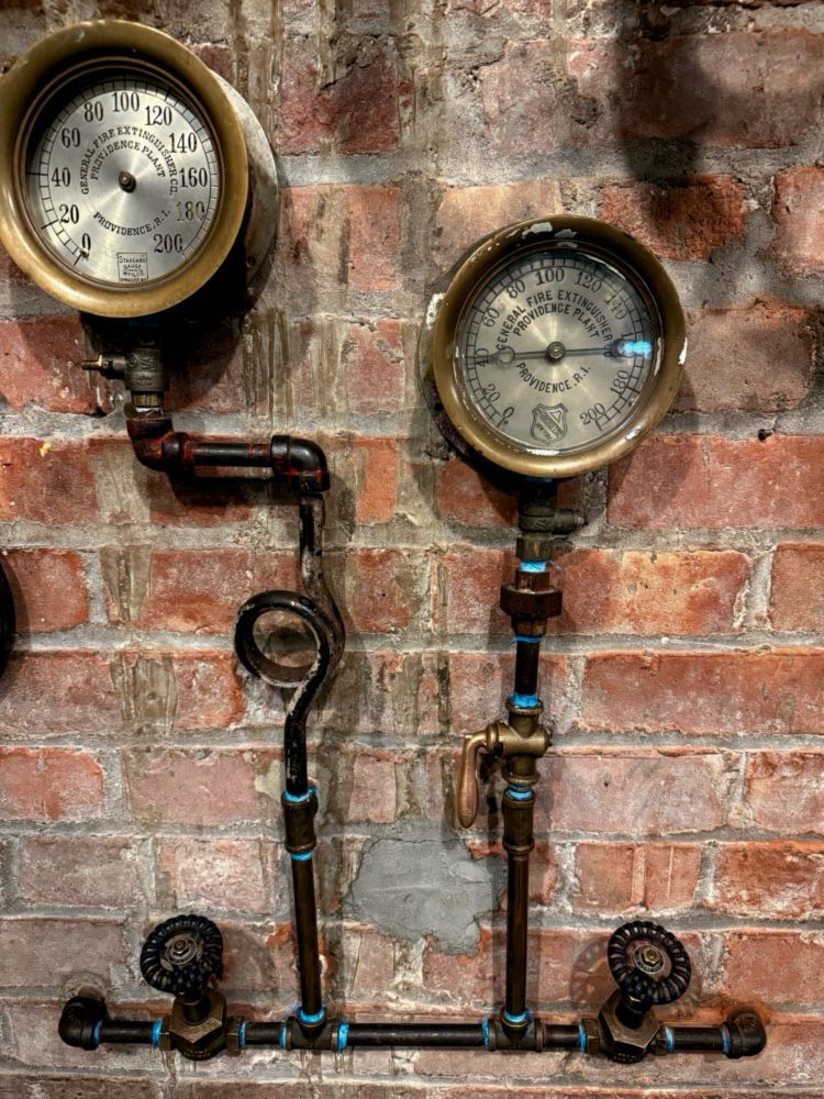Dials and pipes on brick wall