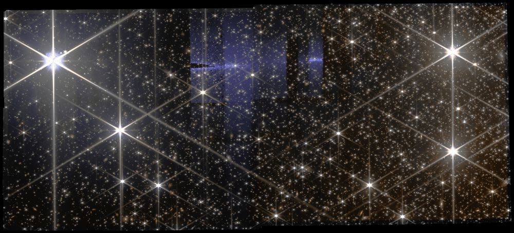 **Alt Text:** A high-resolution image from the James Webb Space Telescope's NIRCam showing NGC-5139, also known as Omega Centauri. The image is filled with countless bright stars, many of which have a starburst effect, lending a sparkling appearance across a dark background. Some regions exhibit faint blue and purple hues, possibly indicating dust or gas in the galaxy. The overall effect is a stunning vista of a dense star cluster in deep space.