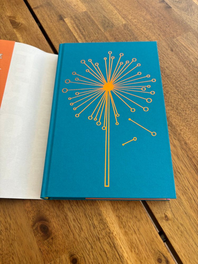 Interior board of the hardback EXTREMOPHILE by Ian Green showing a dandelion in gold