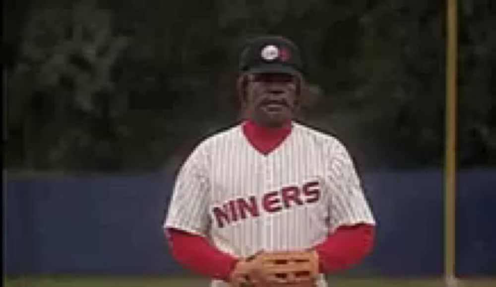 a man in a miners baseball uniform is standing on a baseball field and saying death to the opposition .