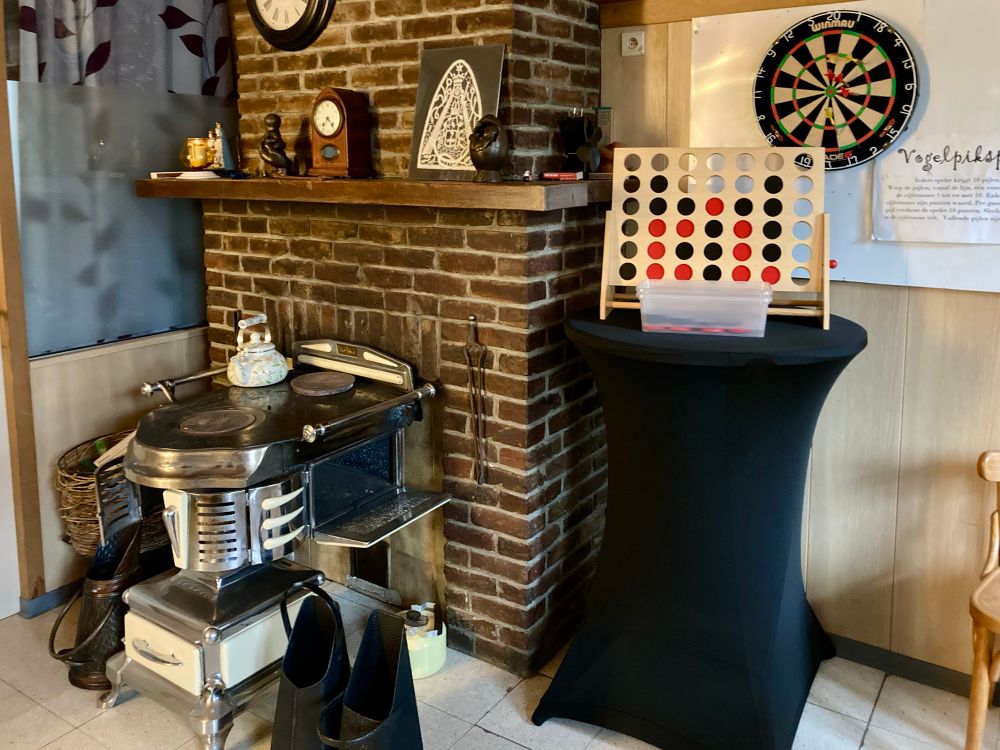 Fireplace with unusual range. A dartboard on the wall in room next to the bar. 