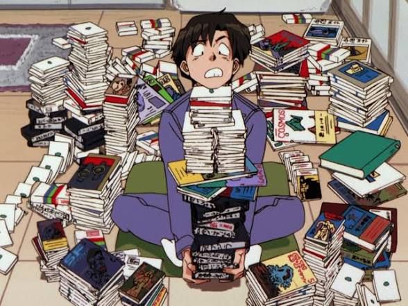 Ken from Otaku no Video, surrounded by video tapes.