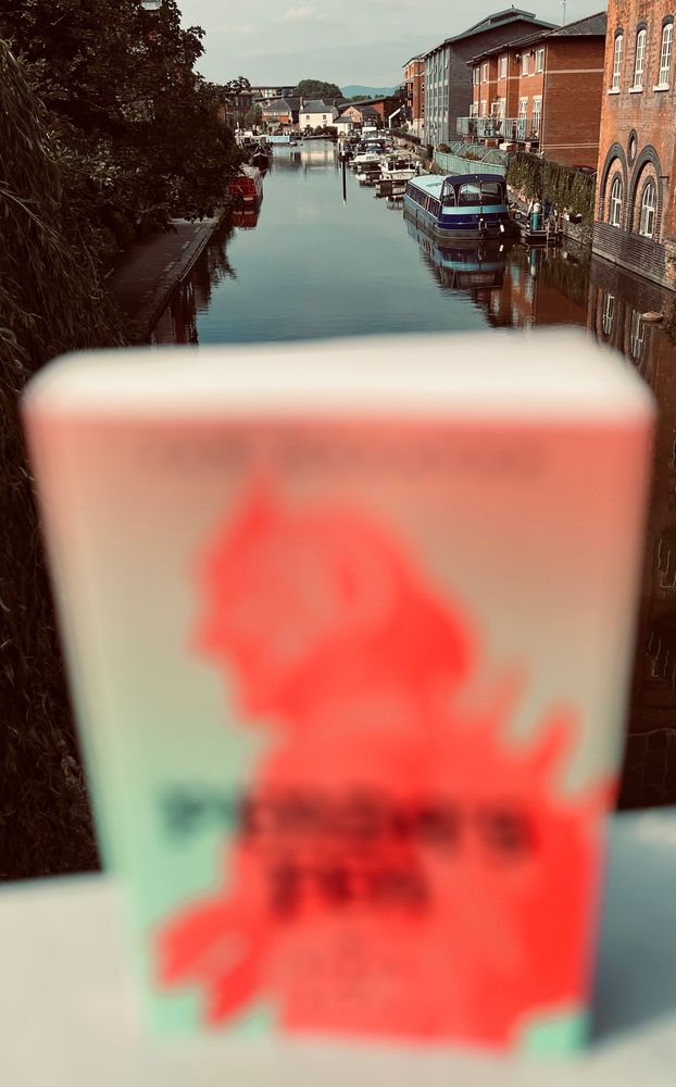 The same image, but the book is out of focus, the background, including distant hills, now in focus. 