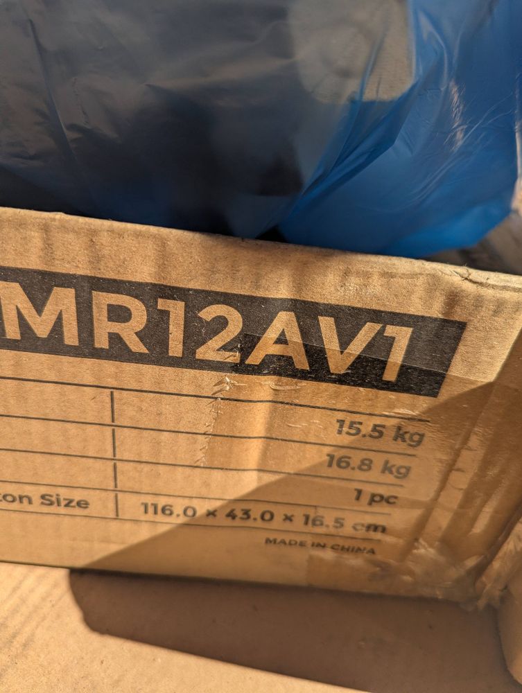 Photo of a cardboard box with "MR12AV1" in block letters in a black rectangle printed on it, along with weights and dimensions of the product it held.