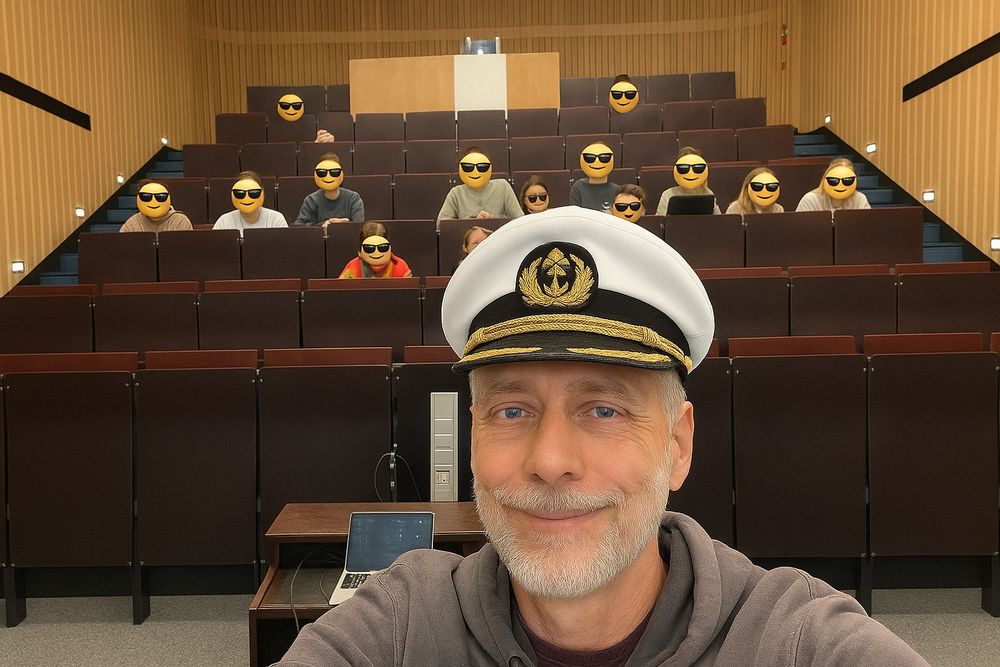 Im Vordergrund imm Hörsaal Michael Schmitt mit der Kapitänsmütze des Alten aus dem Film "Das Boot". Im Hintergrund einige Studierende aus der Vorlesung Spektroskopie und Mikroskopie komplexer Systeme. Die Gesichter sind mit einem Smiley mit Sonnenbrille unkenntlich gemacht.