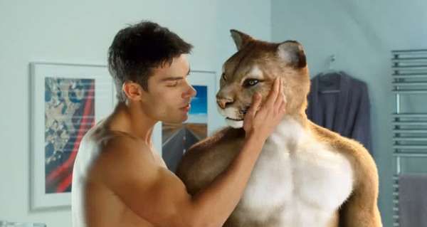 A semi-nude anthropomorphic male cougar being caressed by an attractive young man, taken from an Orangina ad from 2010