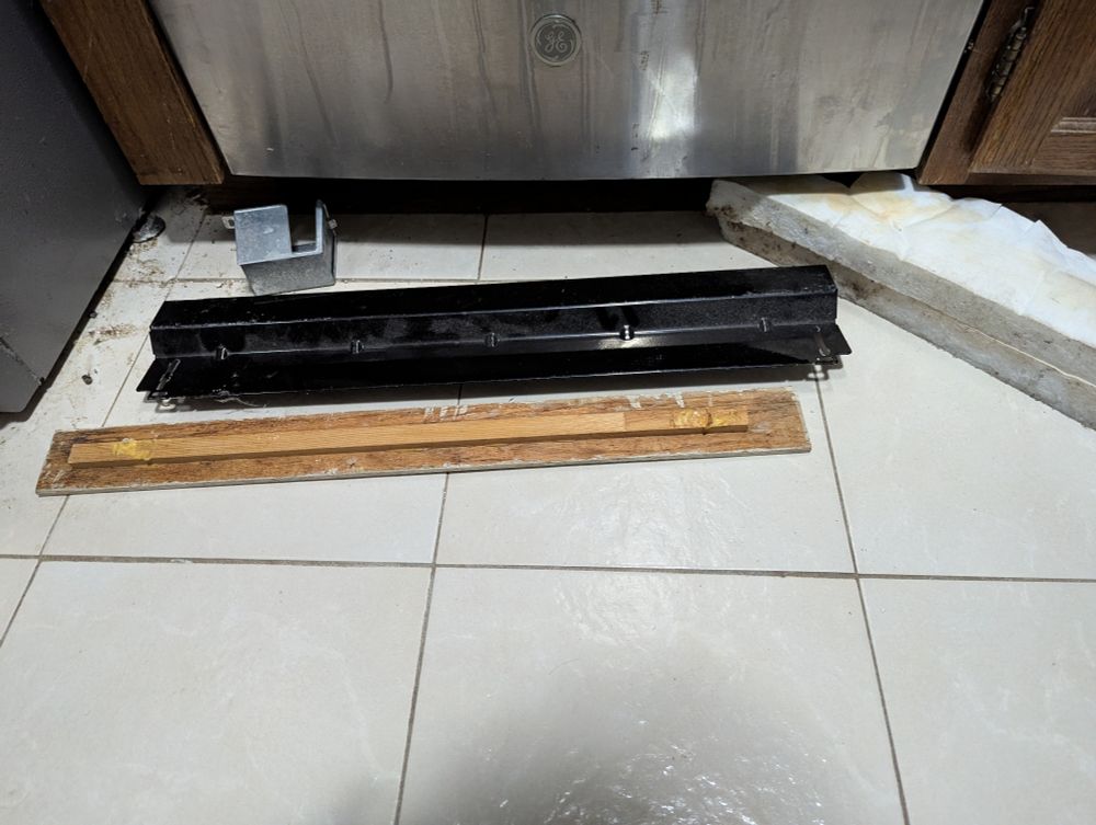 A bunch of shit in front of a dishwasher 
