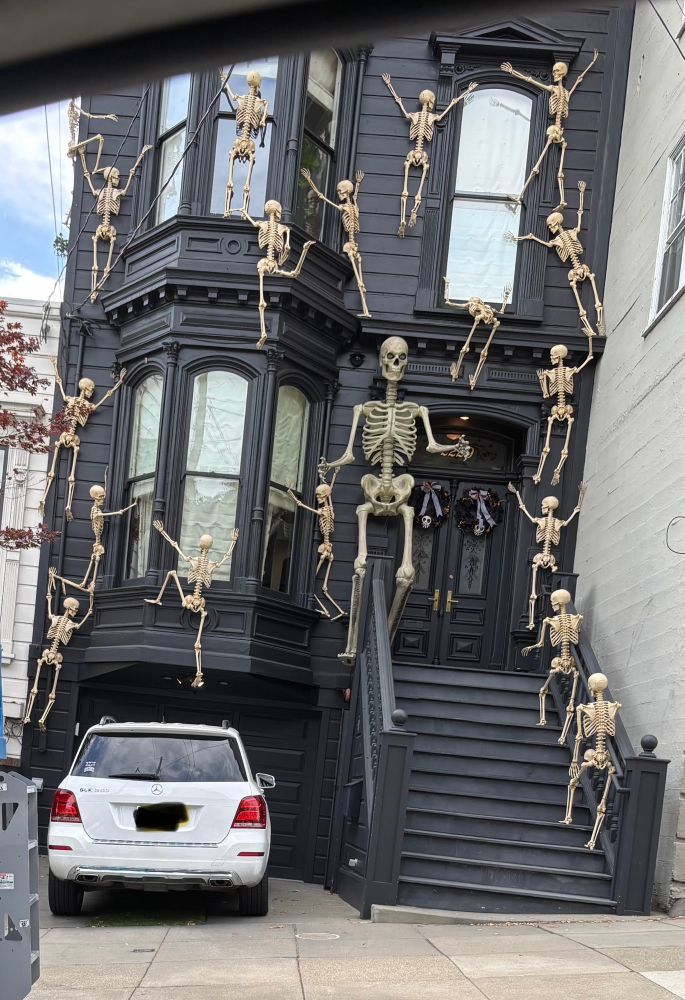 Skeletons climbing exterior of house for Halloween