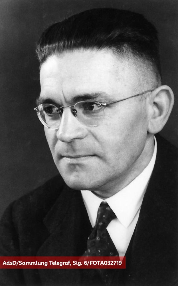 Schwarz-Weiß-Porträt eines Mannes in Anzug und Brille