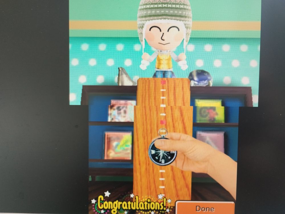 a screenshot of tomodachi life gameplay, in the catch-the-item mini game. in the screenshot, the player has successfully caught the item--a compass.