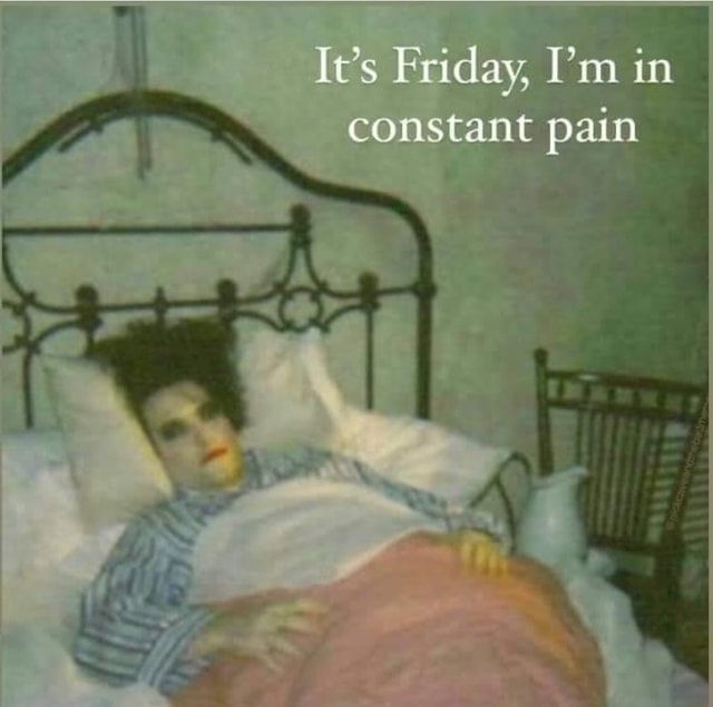 It's Friday I'm in constant pain - Robert Smith maquiado deitado de pijama numa cama antiga de cobertinha rosa