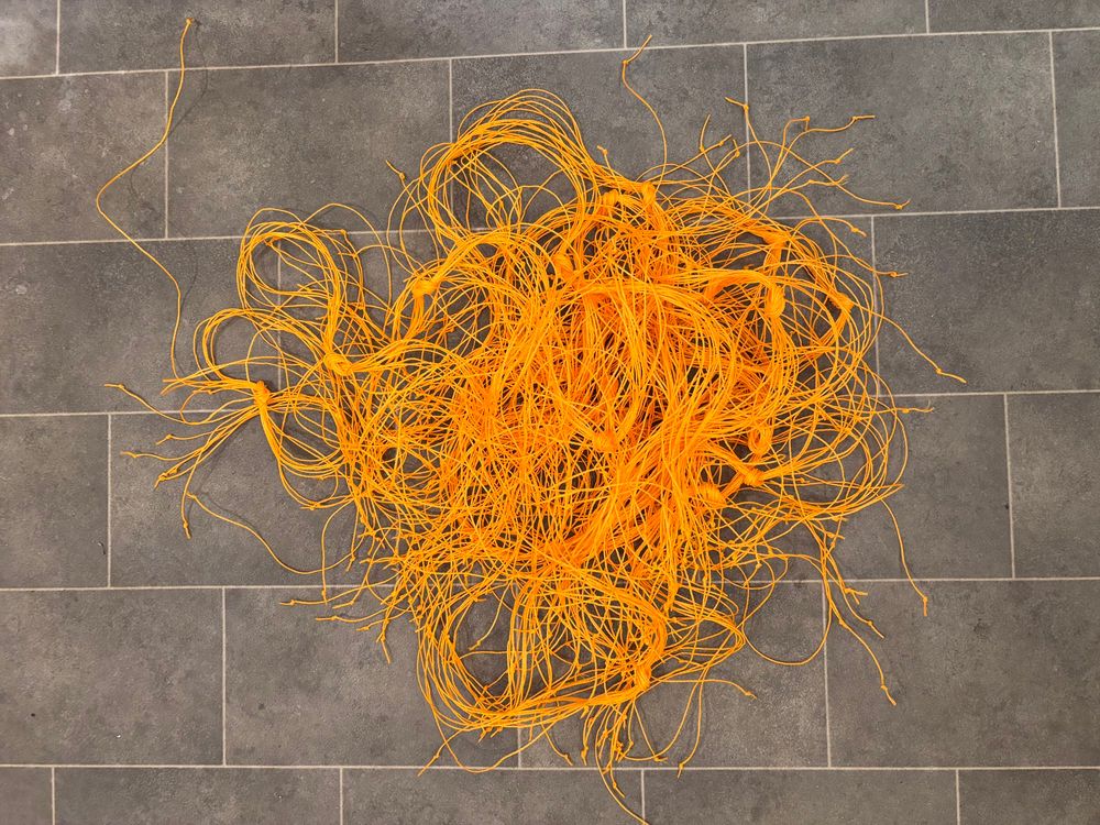 Pile of bright orange strands of string