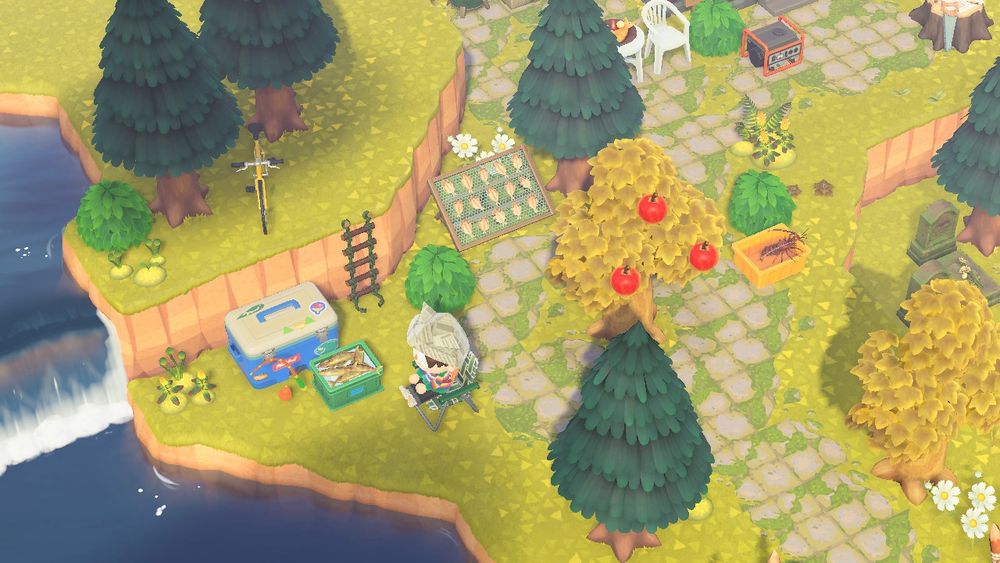 a lawn chair sitting near a waterfall. there’s a fishing pole, large cooler, and buckets with fish and lobsters 