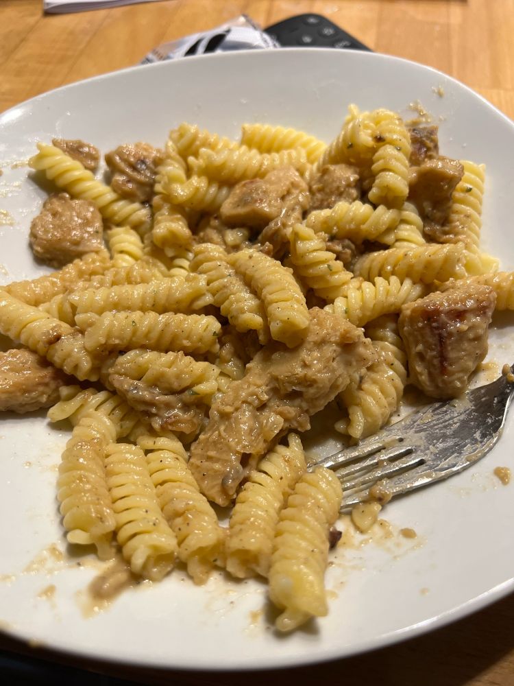 Fusilli in einem weißen Teller mit Soja Geschnetzeltem in Rahmsauce