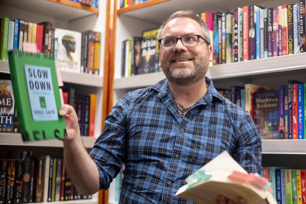 Me holding copies of Slow Down and For Dignity Justice and Revolution, looking winsome