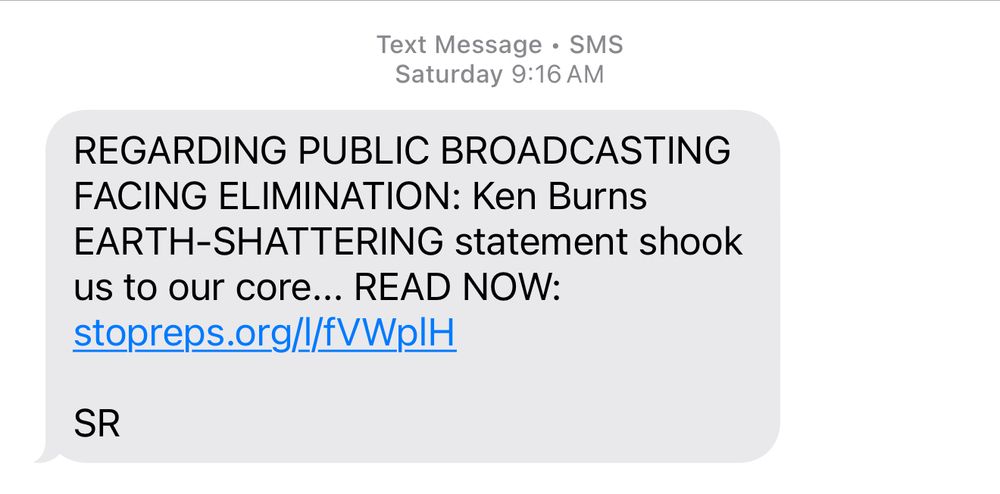 A political fundraising text warning about the elimination of public broadcasting. It claims Ken Burns issued an “EARTH-SHATTERING” statement, encouraging the reader to click a link to “READ NOW.” The message uses all caps for emphasis and ends with “SR.”
