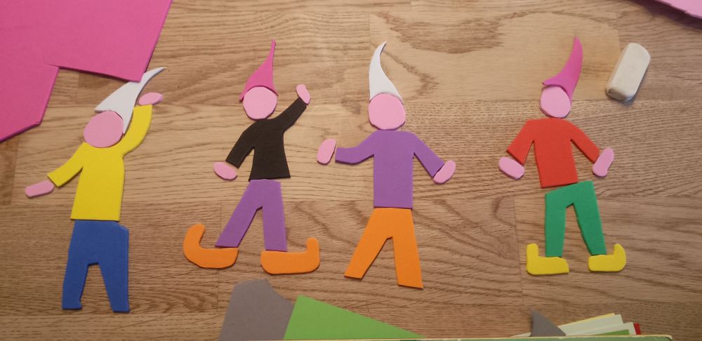 Aus so dünnen Schaumstoff Bastelbögen in verschiedenen Farben zusammengestückelte Wichtel:innen.
Einzeln sind Schuhe, Hose, Oberkörper, Kopf, Hände und Mütz.