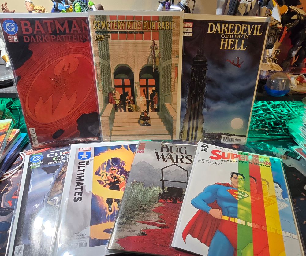 A picture of 7 comic books: Batman: Dark Patterns #9, Cemetery Kids Run Rabid #1, Daredevil: Cold Day in Hell #3, Cheetah & Cheshire Rob the Justice League #1, The Ultimates #15, Bug Wars #6 and Superman: The Kryptonite Spectrum #1.