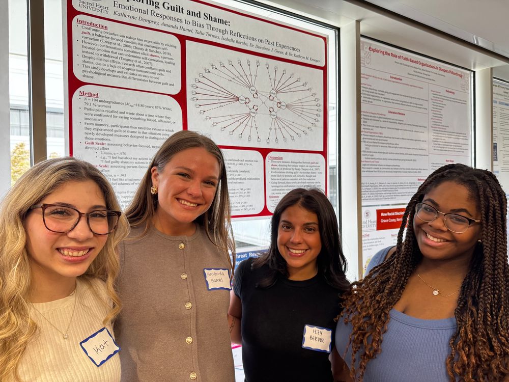 Four students standing in front of their poster at Academic Festival.