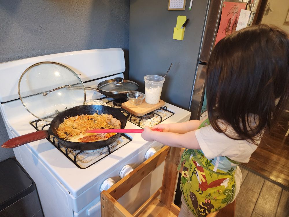 My 3rd old daughter learning about stovetop safety and making her first egg and hashbrown breakfast. 