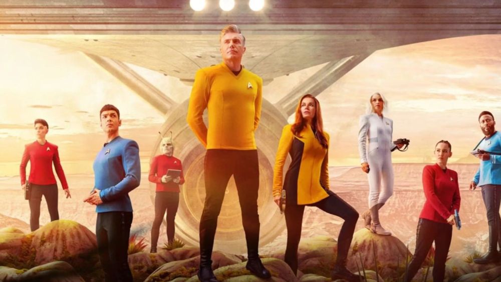 Elenco de protagonistas de Star Trek: Strange New Worlds, con la astronave Enterprise de fondo.