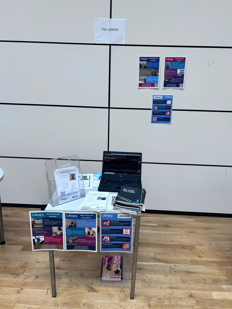 Library display with posters, laptop (with Bloomberg) and leaflets