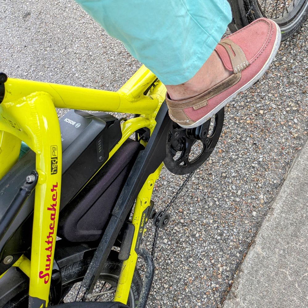 A photo of my right foot on the pedal of a 

yellow Tern HSD cargo bike with its name, Sunstreaker, in red on the seat stay

I'm wearing

dark mauve fabric penny loafers with no socks under a turquoise pantleg