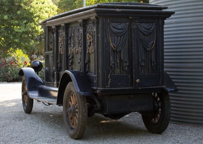 Real view of a 1915 Studebaker motor hearse showing the elaborately carved curtains and columns