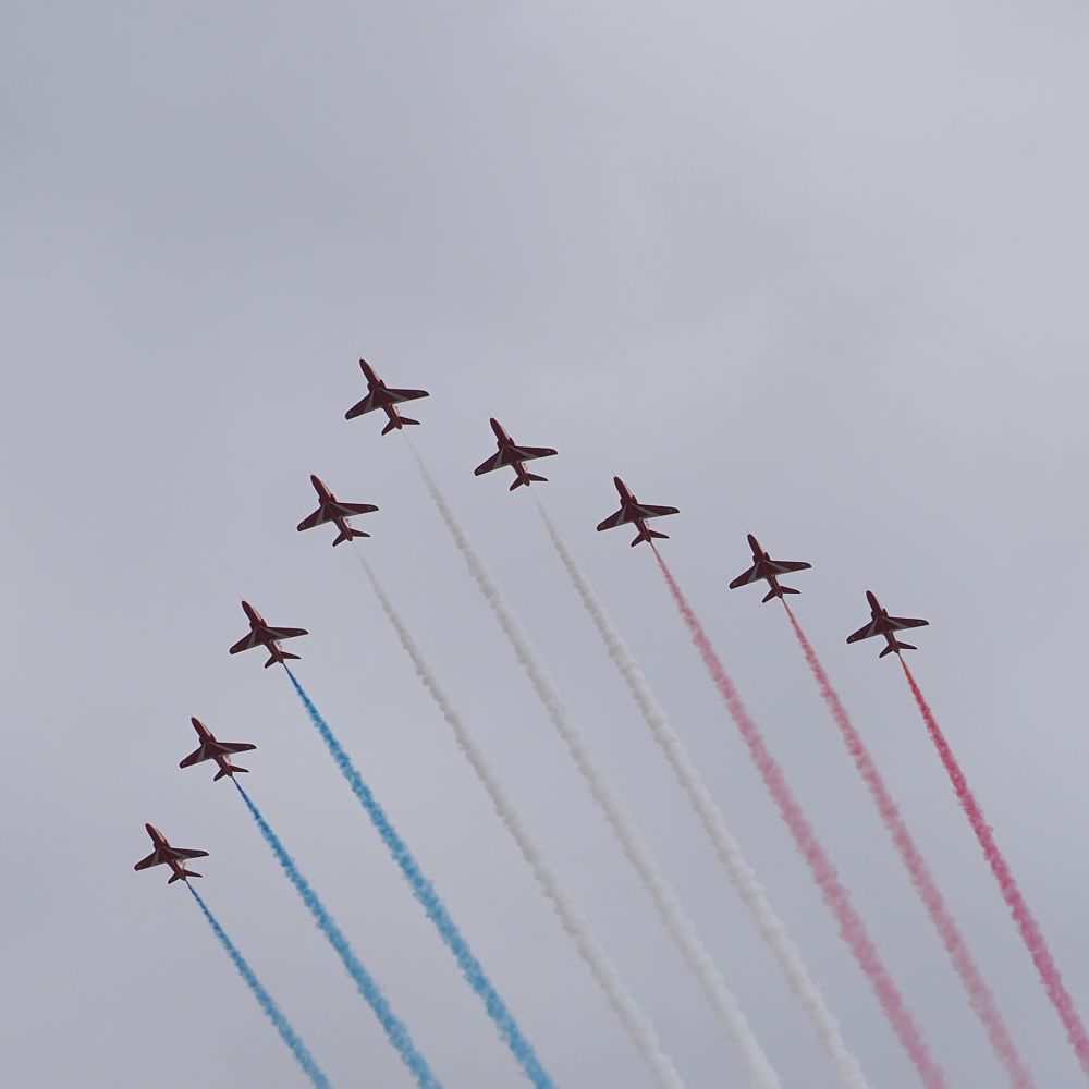The RAF Red Arrows in V formation, trailing red, white & blue smoke