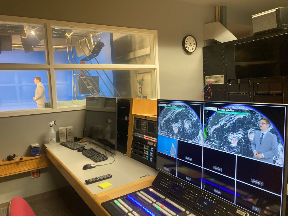 View of the production room in the UND Weather Update studio, with student Cole presenting the day's forecast on camera.