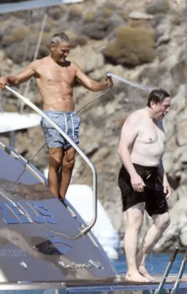 An amphibious creature being soaked in water by some middle aged guy who looks like he owns a Mazda dealership in Redding