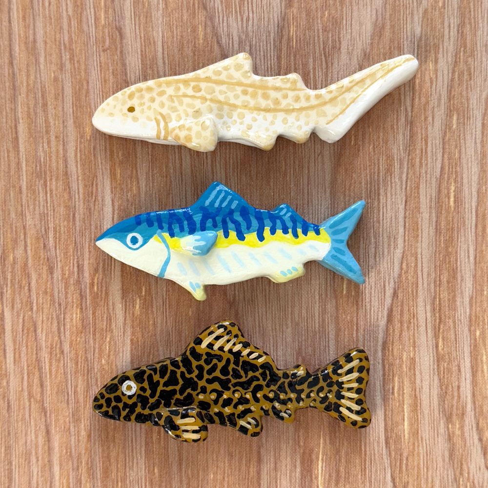 Air dry clay magnets of a zebra shark, mackerel, and pleco.