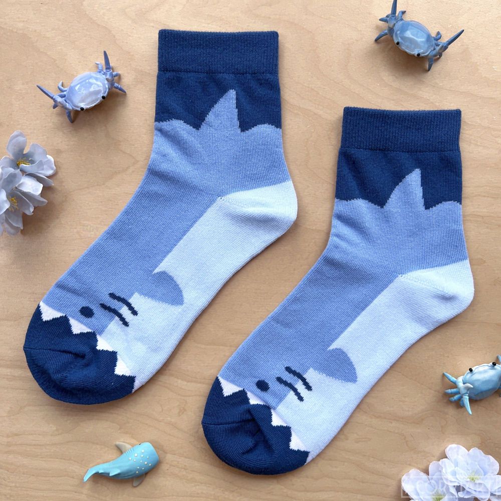 photo of a pair of socks laid flat. the socks look like great white sharks