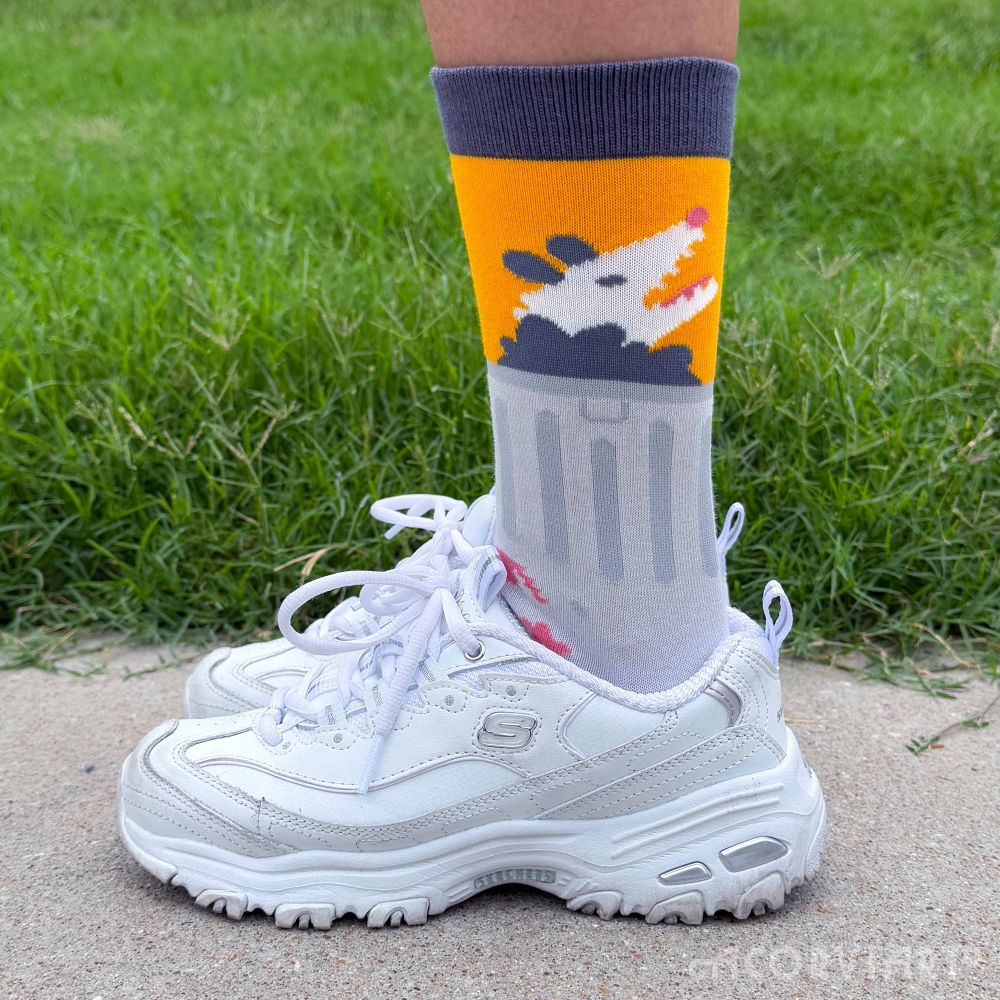 Trash being worn with shoes, with the opossum and trash can peeking out from the shoe.