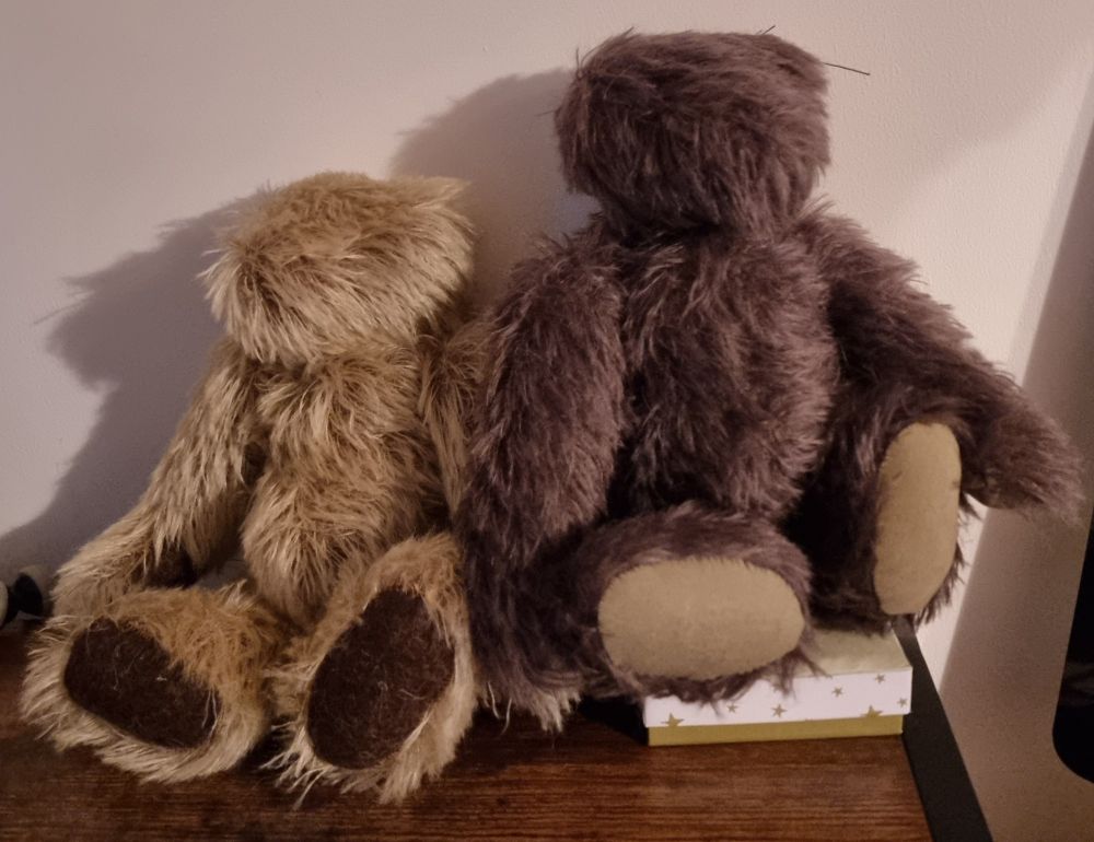 Two handmade traditional mohair teddy bears in an unfinished state, missing faces and ears.