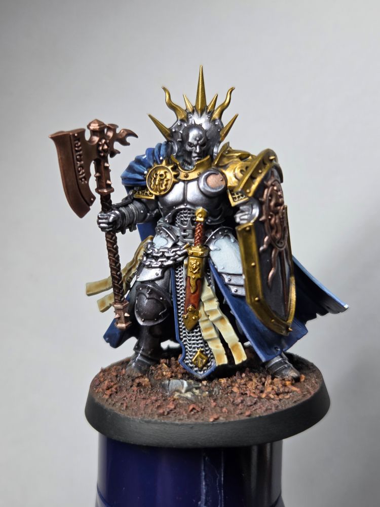 Front view of a Stormcast Eternal Reclusian miniature painted in a blue, silver and gold scheme