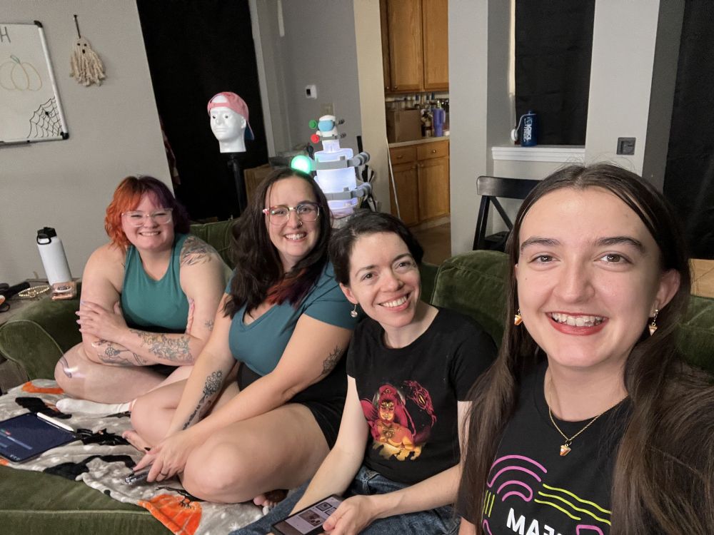 A group of people sitting on a couch smiling at the camera! 