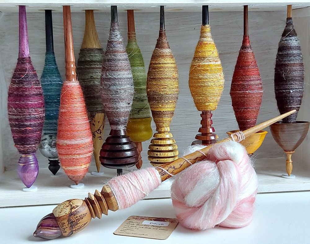 a close up of a colorful selection of supported spindles in a custom made wooden stand
