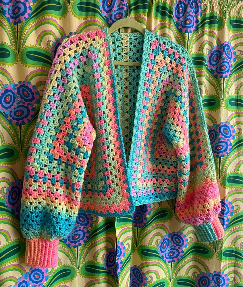 A a candy coloured striped cardigan on a flamboyant floral background 