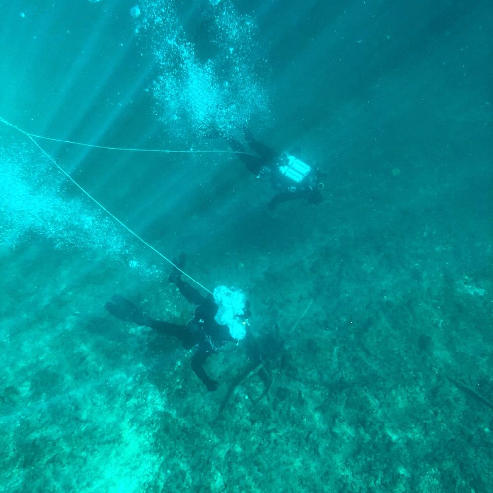 Zwei Minentaucher im sonnendurchfluteten Wasser 