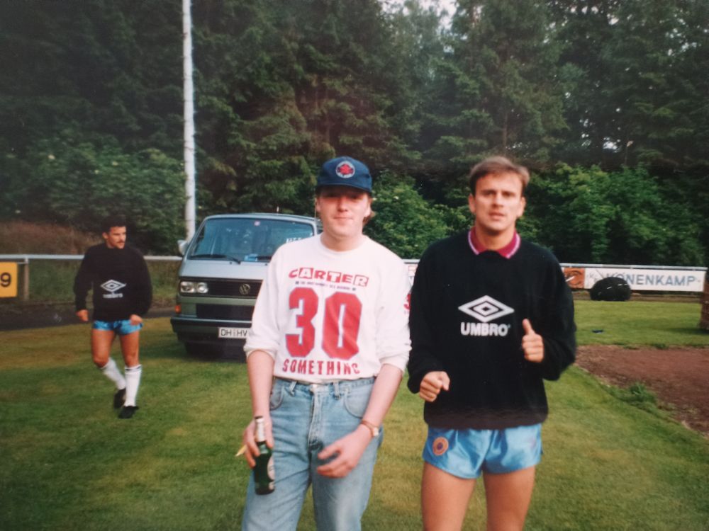 A supporter stood next to footballer Darius Kubicki. Syke, Germany 1991.